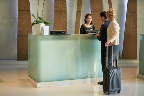 Smiling Receptionist Working at Hotel Lobby
