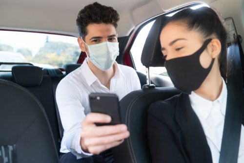 Man showing something on phone to cab driver.