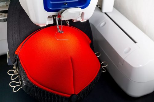 Red cap on the hoop og embroidery machine close up images